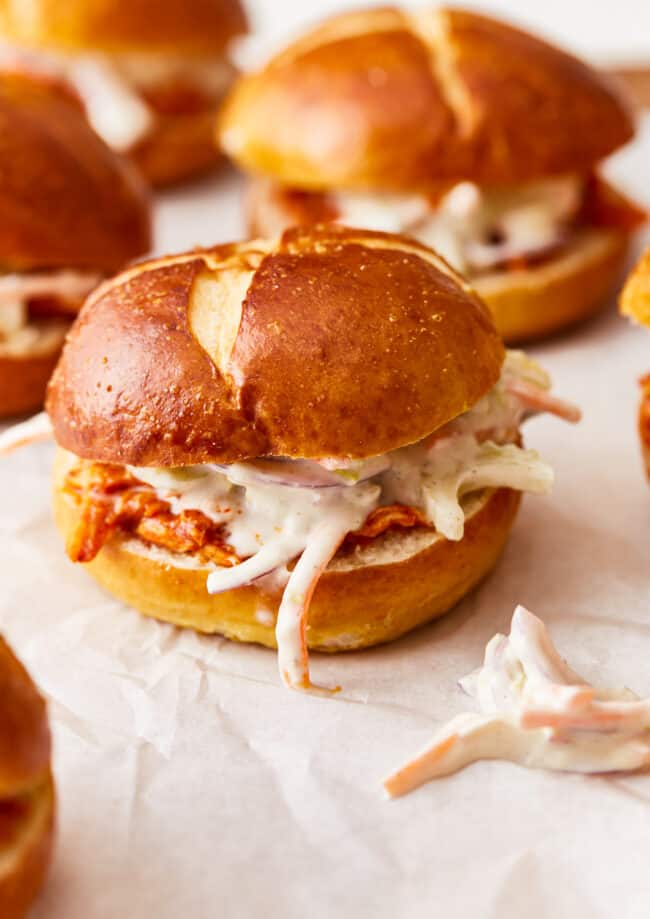 A group of sandwiches with coleslaw on them.