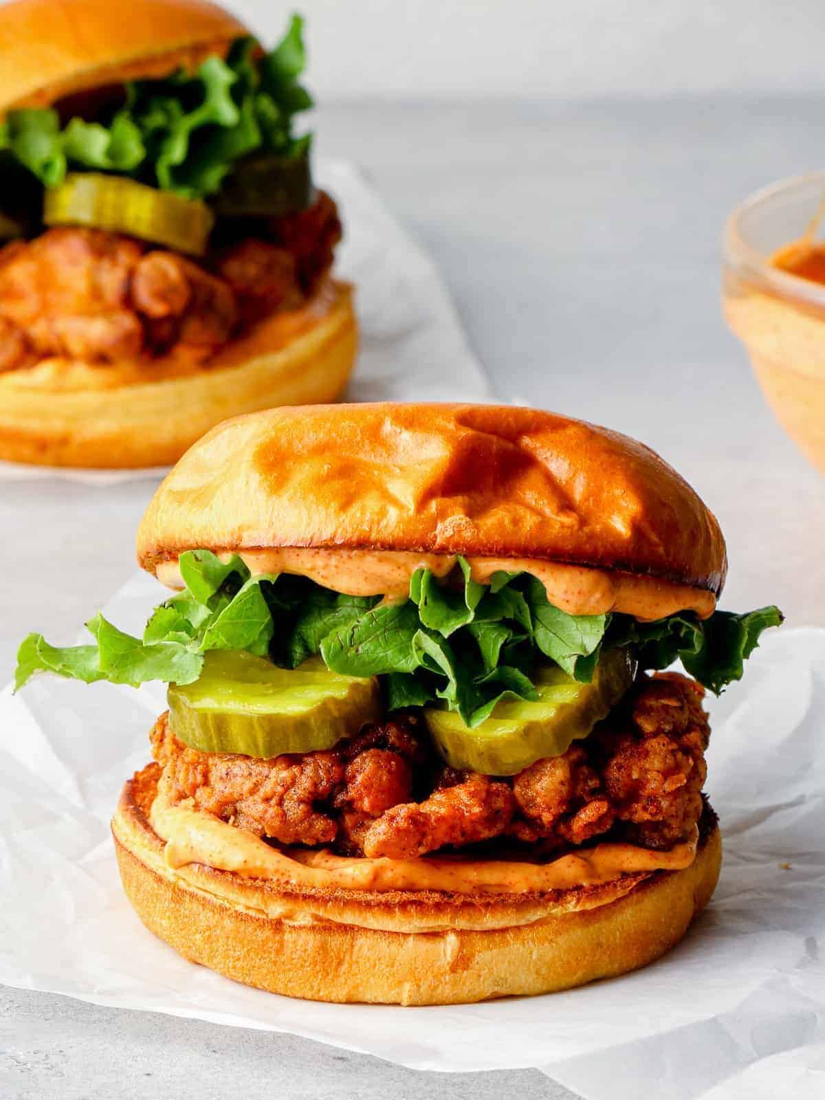 fried chicken sandwich with sauce and pickles