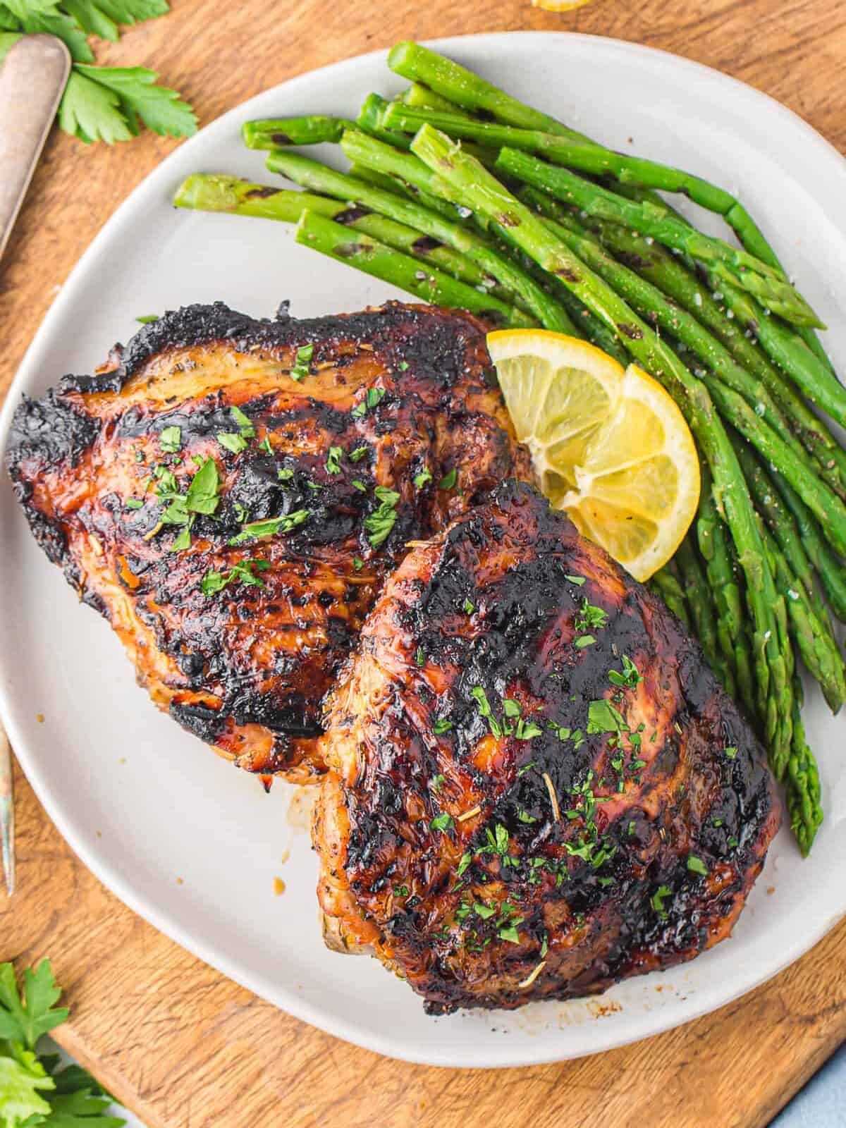 plate of grilled chicken thighs with asparagus