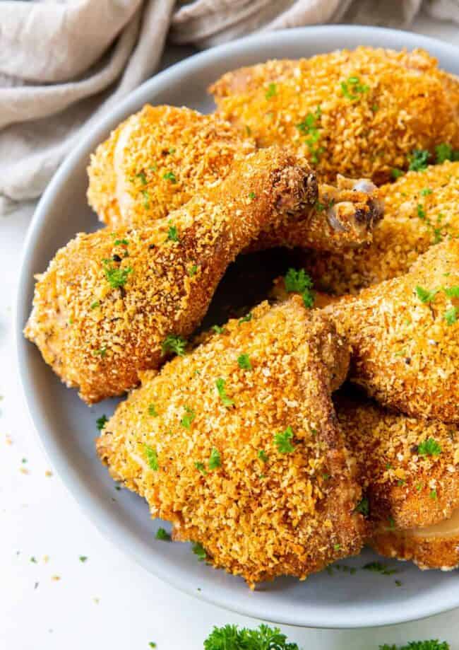 close up on a plate of shake and bake chicken drumsticks and legs