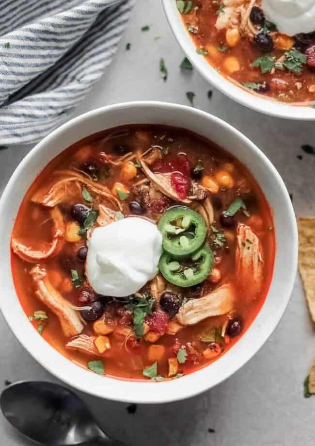 Mexican chicken soup with sour cream and tortilla chips, reminiscent of Chicken Enchilada Soup.